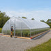 Installed outdoors with person at entrance and crops inside Tunnel Greenhouse Grow Tent